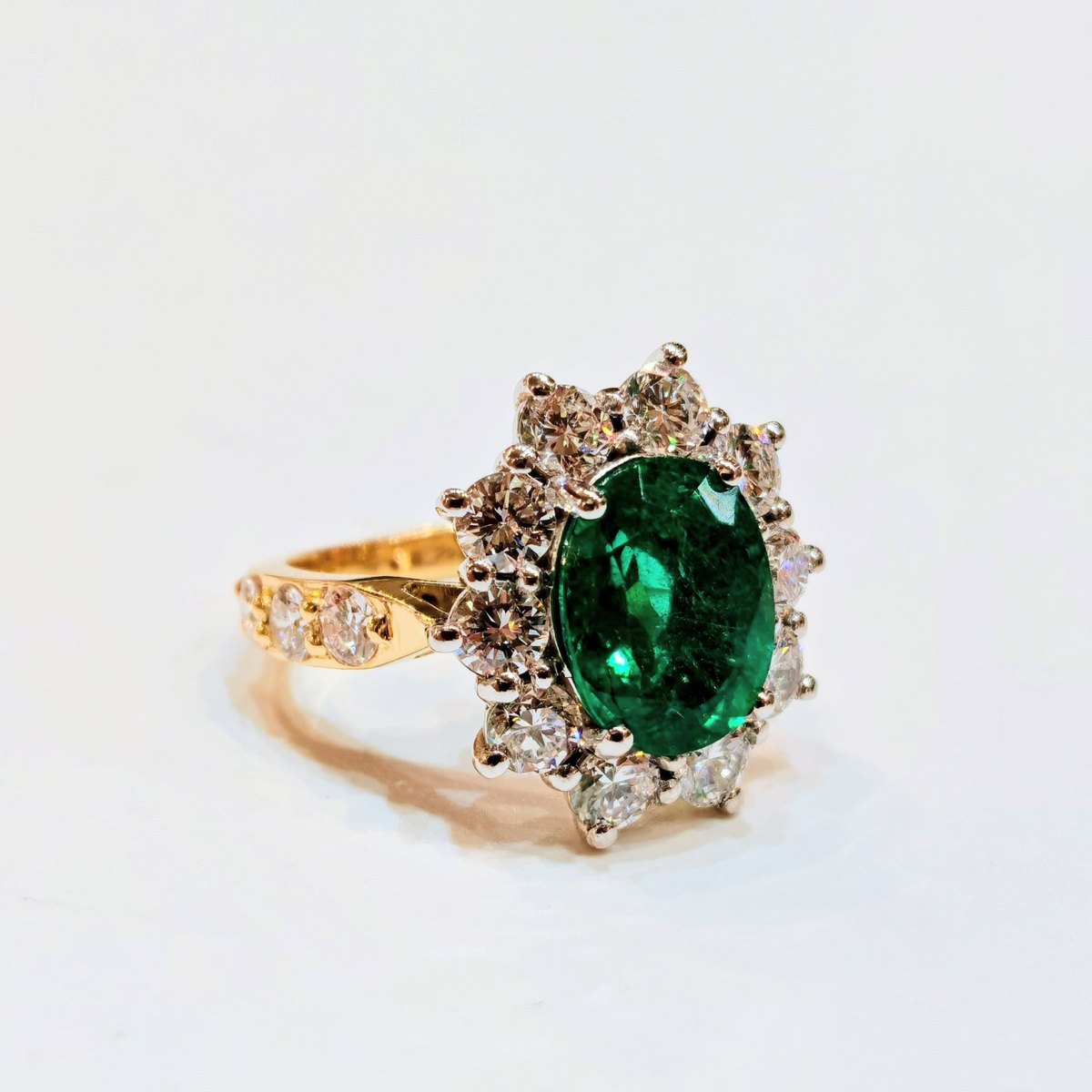 Toulson Jones Jewellers portfolio piece, Oval emerald  brilliant-cut diamond halo  18ct yellow gold, diamond-set shoulders