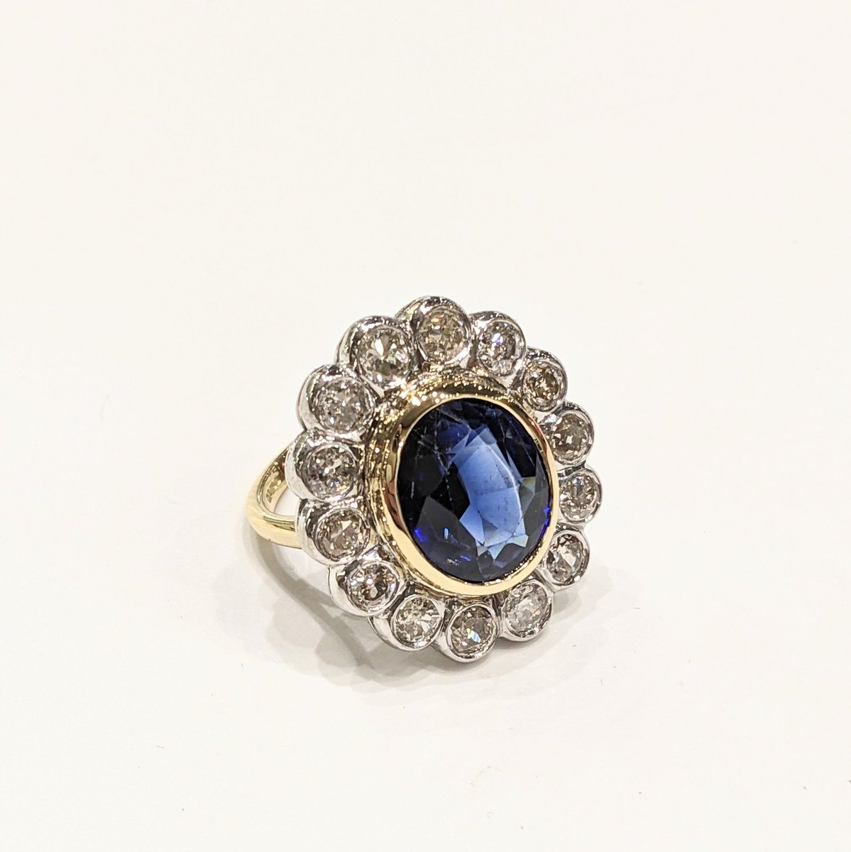 Toulson Jones Jewellers portfolio piece, Oval sapphire centre  old-cut diamond bezel cluster  two-tone 18ct gold